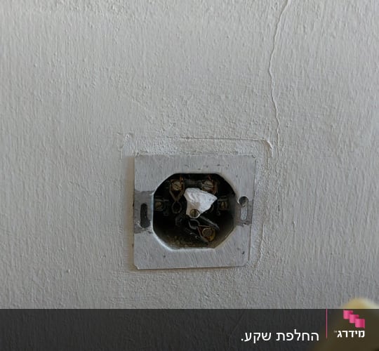שקע חשמלי פתוח עם חוטים חשופים בקיר